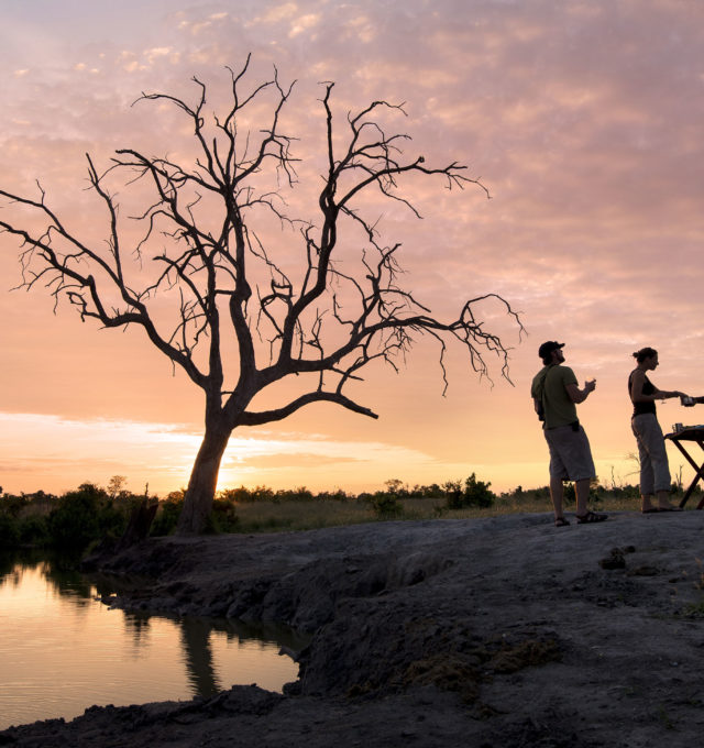 Silhouetted people by the lake at Somalisa Camp, Hwange National Park